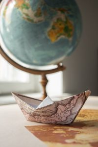 Globus und Papierschiffchen auf historischer Landkarte, Quelle: Pexels.com, Urheber: Monstera